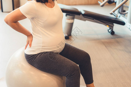 活跃的孕妇在瑜伽室的健身中心锻炼图片