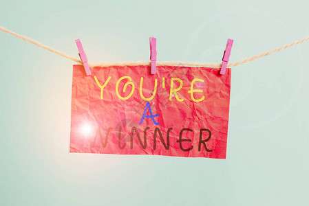 手写文字写你是赢家概念照片赢得第一名或竞赛冠军晾衣绳夹矩形纸图片