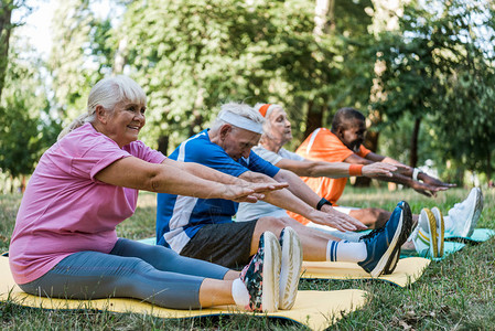 运动型退休和多元文化男和女在健身垫上锻炼的运动服图片
