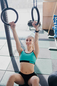 金发女人在健身房里用体操环锻炼图片
