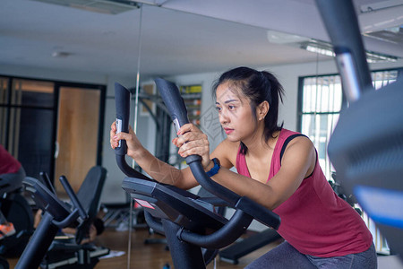 女子电动自行车在健身房锻炼图片