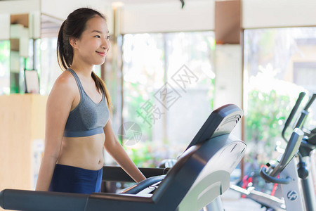 用健身器材在健身房室内锻炼身体健康的美丽亚洲图片