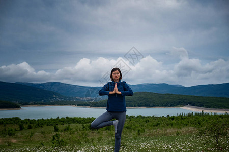 一名年轻女子在田野里做哈达瑜伽图片
