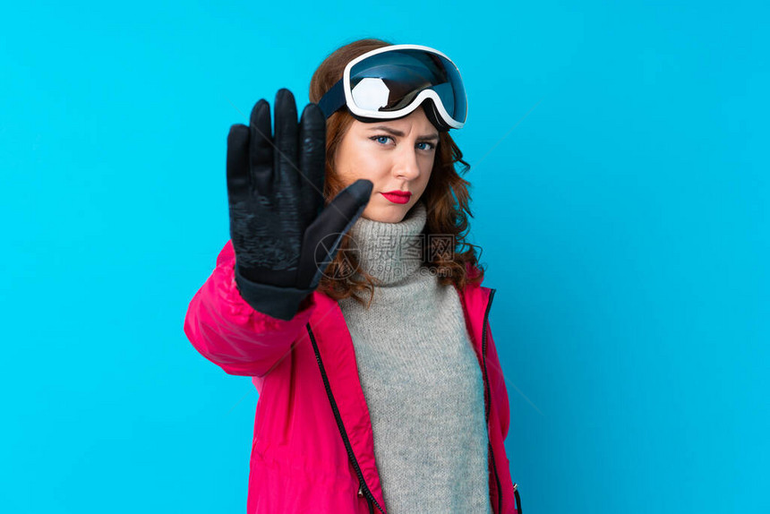 穿着滑雪眼镜的滑雪女人在孤立的蓝墙上图片
