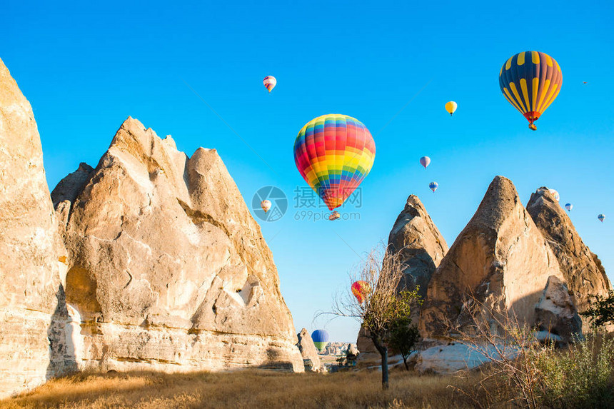 五颜六色的热气球飞过土耳其卡帕多西亚格雷梅内夫谢希尔的童话烟囱在壮观的卡帕多西亚土耳其图片