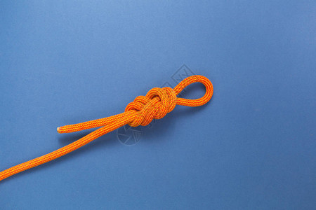 蓝色背景上的橙色攀岩绳安全结安全结八图片