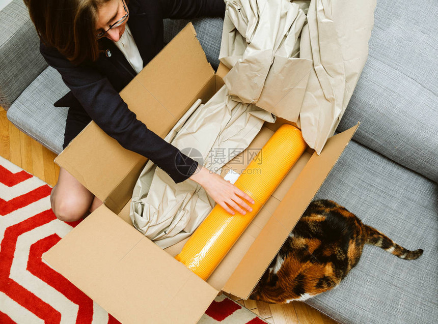 商业女商人在她的宠物猫的美丽动物的帮助下把装有黄瑜伽zen垫子的无箱图片