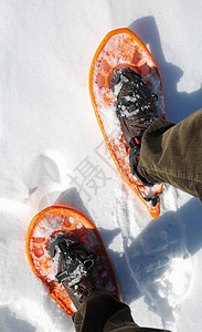 白雪上穿着灯芯绒裤和雪鞋的男人图片