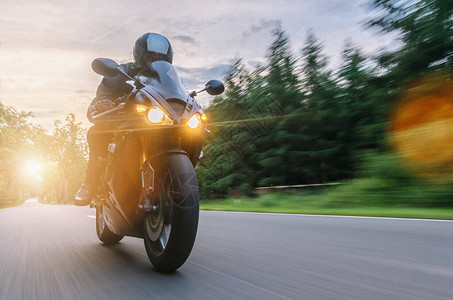 日落时骑在森林路上的摩托车在空旷的路上骑摩托车旅行个人文图片