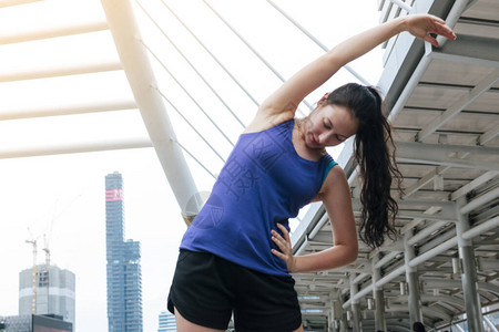 女人在现代城市伸展身体运动图片