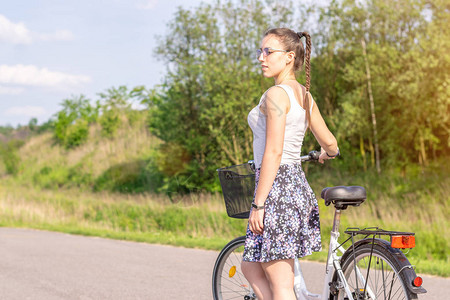 积极的生活一个骑自行车的女人在夏天的森林里欣赏风景自行车和生态图片