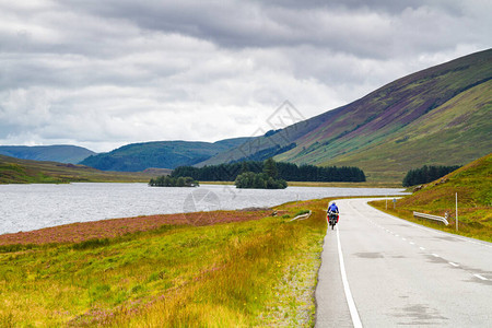 单人骑自行车的女骑自行车穿越苏格兰山脉图片