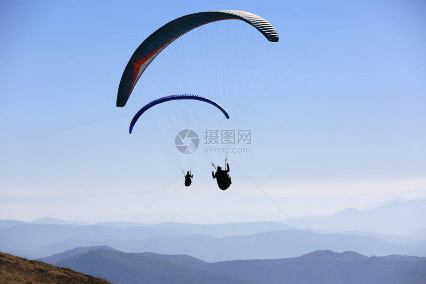 滑翔伞在空中飞越山脉图片