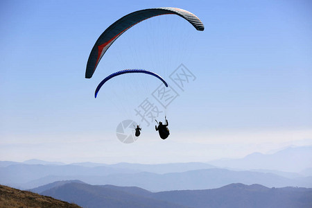 滑翔伞在空中飞越山脉图片