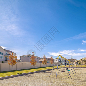 俯瞰小型儿童游乐场空荡的长凳俯瞰着一个带A型秋千的小型儿童游乐场背景图片