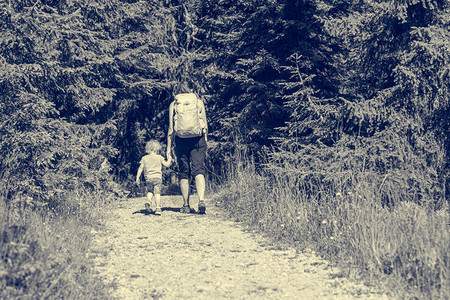 母亲和女儿在森林道路上徒步自然而地图片