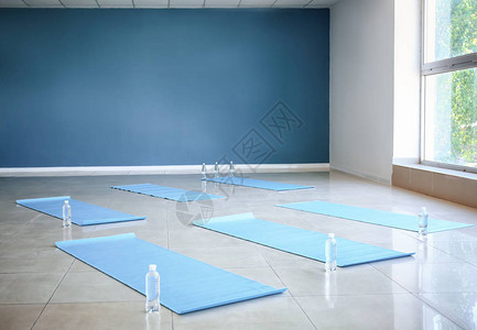 健身房地板上的瑜伽垫和瓶装水图片