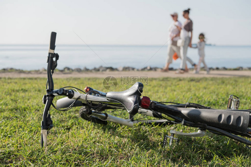 海边报告自行车在绿草地上人们沿着水行走夏天阳图片