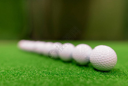 Golf球在绿面周围散射图片