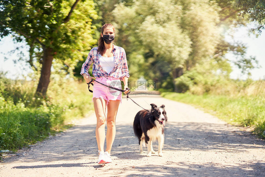 在农村走狗和戴面罩的妇女图片