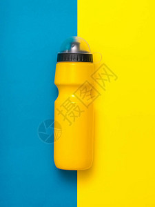 黄色运动瓶子盖在黄色和蓝色背景图片