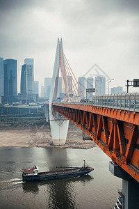 在重庆与城市建筑的桥下船经背景图片