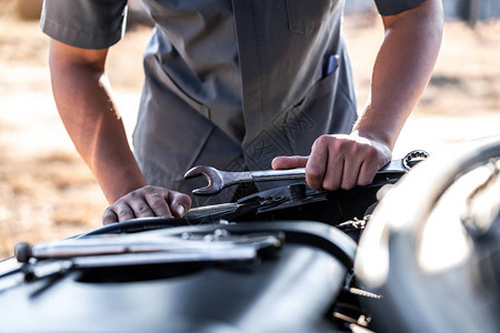 汽车修理工的技术员手在做汽车维修服务和维修工人用扳手修理车辆服务和图片