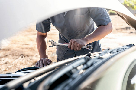 汽车修理工的技术员手在做汽车维修服务和维修工人用扳手修理车辆服务和图片