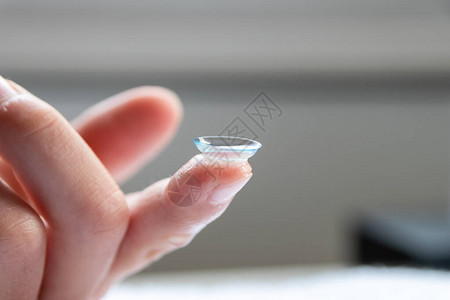手指上的隐形眼镜矫正近视和力模糊配镜师或眼科医生的视力是用透明的一次镜片微距矫正远图片