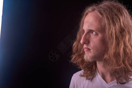 白T恤长金发和蓝眼睛的白人男子在看光源放文字背景图片
