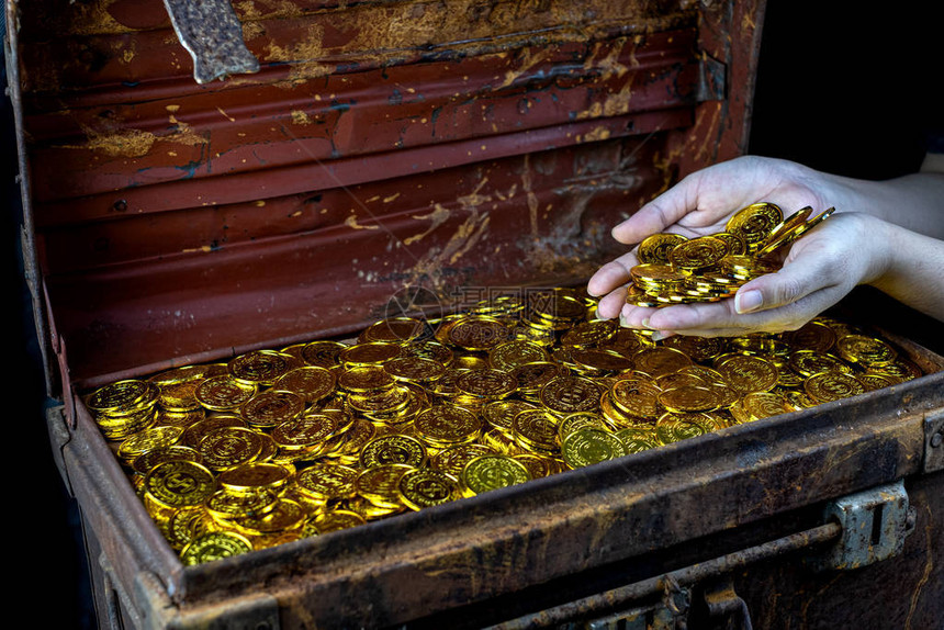 大量堆叠的金币在女士手中宝图片