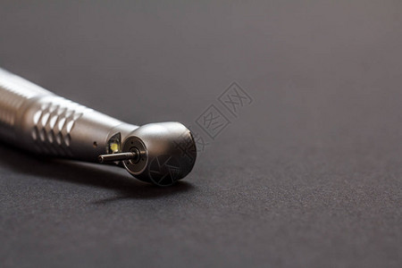 黑色背景上的高速牙科手机头用于牙科治疗的牙科器械医疗工具特写图片