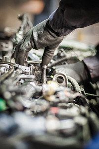 汽车主汽车修理工维修服务技术人员的特写检查和修理汽车服务店引擎盖下图片