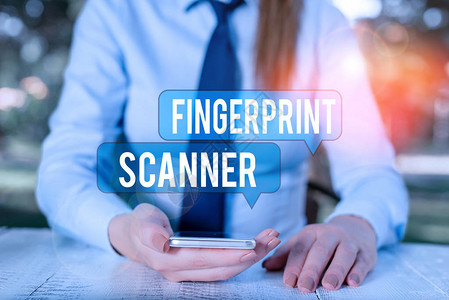文字书写文本指纹扫描仪商务照片展示使用指纹进行生物识别验证以授予访问权限坐在桌旁手持机的背景图片