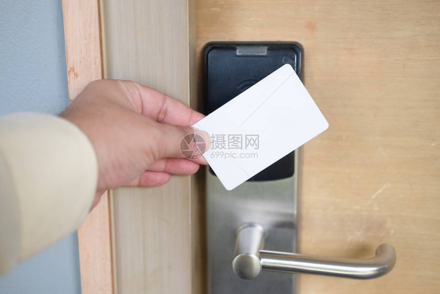 男子手使用钥匙卡开关打开酒店房间门持磁卡用于门禁控制扫描钥匙卡以图片