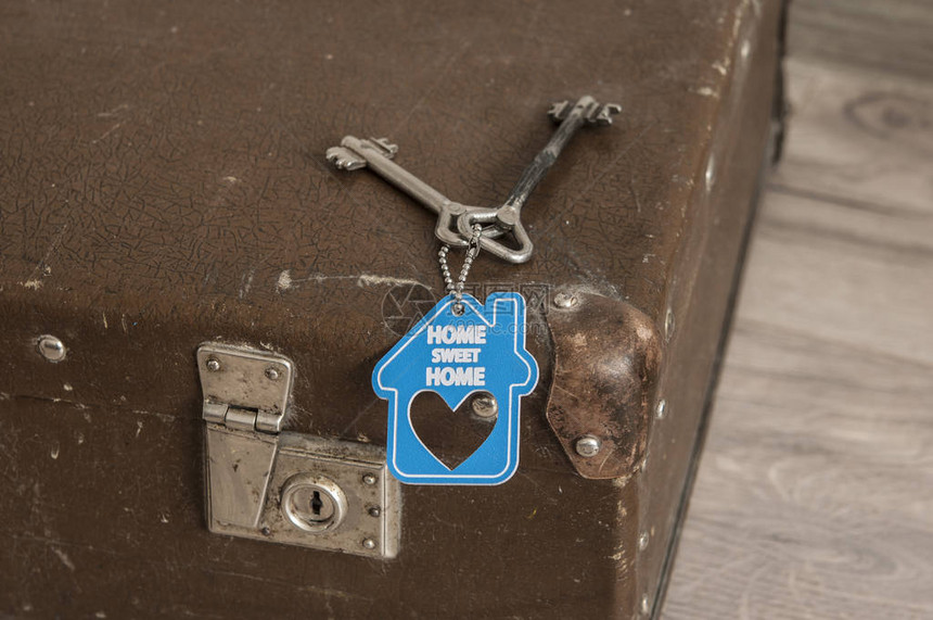 质朴的皮革复古手提箱和旧的两把钥匙与标志回家甜蜜的图片