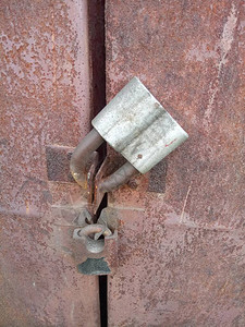 生锈的铁门上的两把旧挂锁图片