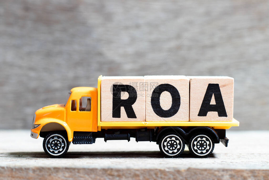 卡车在木材背景上持有用ROA字写成的字母块资产回图片