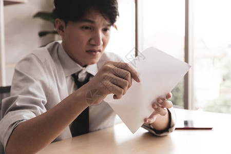 年轻商人在他的办公桌被他读的东西吓得惊呆图片