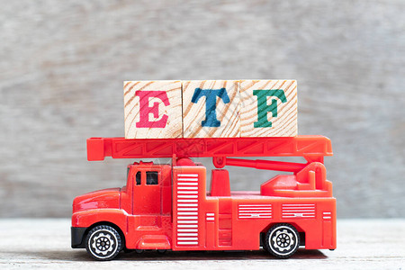红色消防车在木材背景上用ETF外汇交易基金押图片