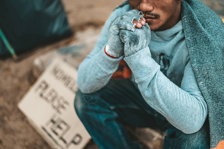 一个人坐着一个无家可归的乞丐请图片