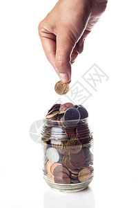 男手把硬币放在罐子里的特写金融概念图片