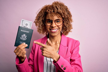 拿着美国护照和美元钞票的年轻非洲裔美国卷发女非常高兴地用图片