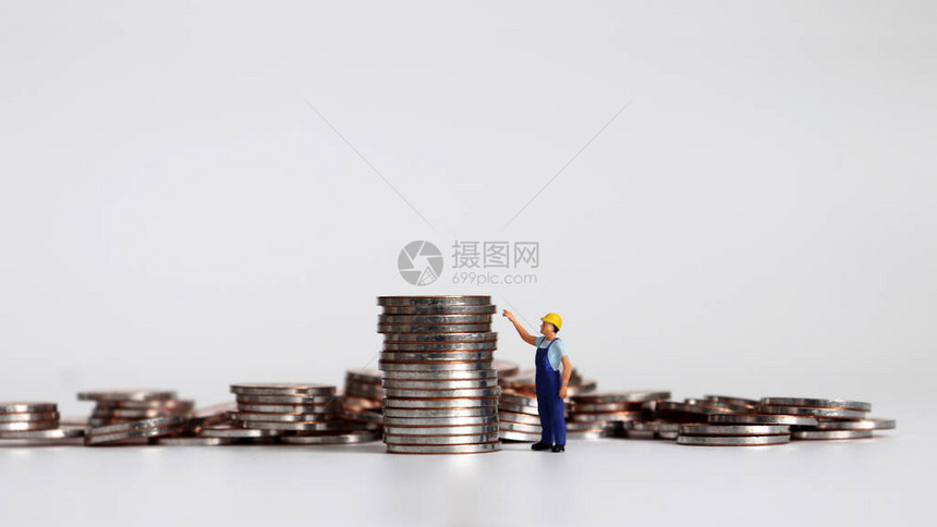一个微型工人指着一堆硬币图片