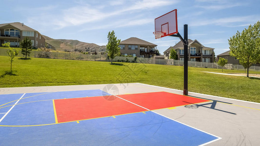 全景框架有山和蓝天背景的室外公共篮球场在这个休闲公园里还可以看到背景图片