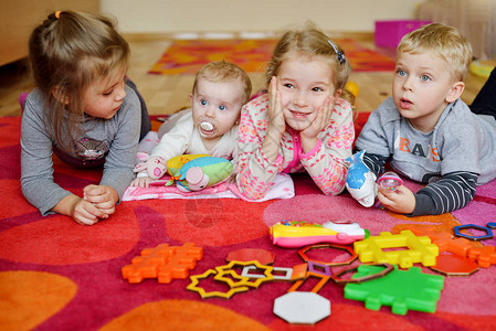 幼儿园婴儿和童在地毯上玩耍图片