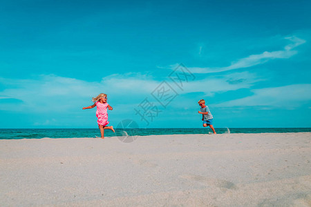 快乐的孩子男孩和女孩在热带海滩上奔跑图片