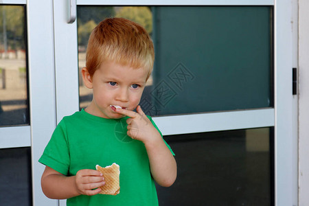 一个三岁的男孩在街上吃冰淇淋呢他图片