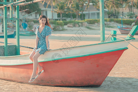 亚洲女人坐在海滩船上享受夏季海滩度图片