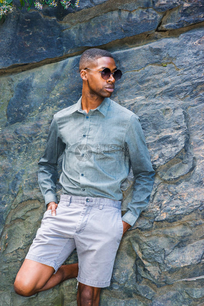 身穿长袖灰色衬衫短裤太阳镜的非裔美国青年男子图片